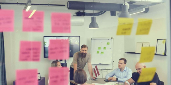 Planning in workshop, people around the table, post-in notes on the wall